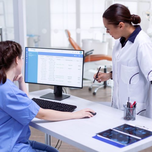 stomatolog-nurse-tooth-clinic-checking-patient-appointment-looking-computer-monitor-stomatology-assistant-teeth-doctor-discussing-reception-dental-office (1) stomatolog-nurse-tooth-clinic-checking-patient-appointment-looking-computer-monitor-stomatology-assistant-teeth-doctor-discussing-reception-dental-office (1)